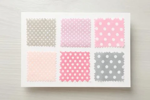 Samples of fabrics with polka dot pattern on light wooden table, top view Fotos de archivo