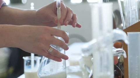 Samples in the laboratory. Add substance from a pipette to milk. Work. Stock Footage 127742639