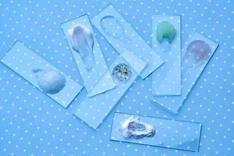 Samples of multi-colored cosmetic products on a blue polka dot background. 스톡 사진