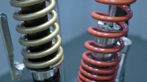 Samples of new automotive shock absorbers with springs at the exhibition Stock Footage 340461598