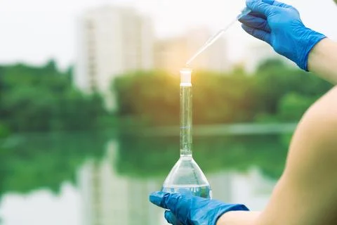 Sampling from open water. A scientist or biologist takes a sample of water fr Stock Photos