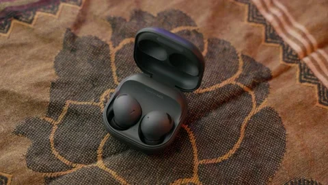 Samsung Air Buds on bed sheet on its case Stock Footage 218446050