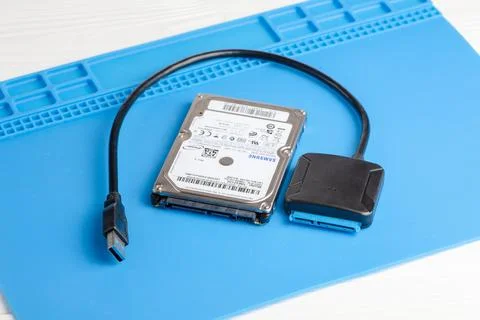 Samsung HDD disk with USB adapter on a blue mat for connection Stock Photos