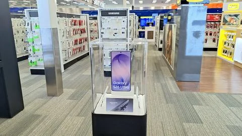 Samsung smartphone on display in electronics retail store. Stock Photos