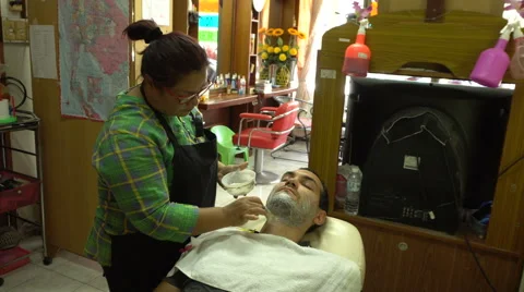 Samui, Thailand - 1 October 2016: Female barber shaving caucasian man Stock Footage 68208993