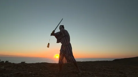 Samurai-inspired painted man weilding a samurai sword - HD 25P. Stock Footage 87248170