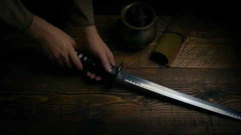 Samurai Sword Is Picked Up Off Table Stock Footage 102870474