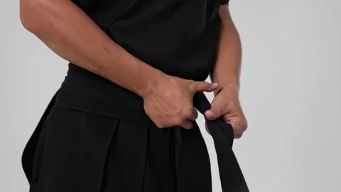 Samurai tying a knot on a belt on a black kimano Stock Footage 211706432