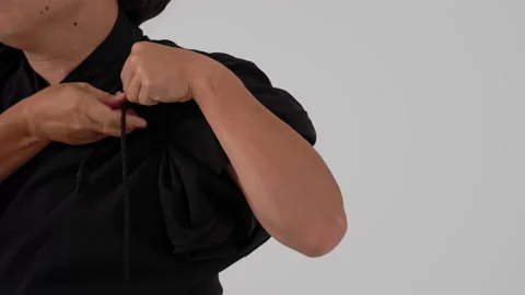 Samurai tying a knot on a black kimano to support the sword Stock Footage 211692032