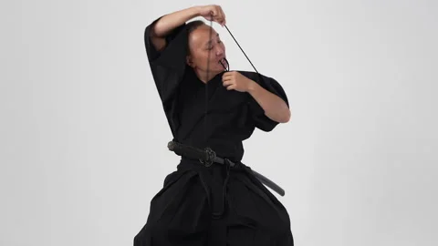 Samurai tying a knot on a black kimano to support the sword Stock Footage 211701795