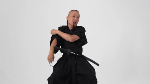 Samurai tying a knot on a black kimano to support the sword Stock Footage 211707812