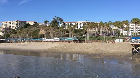 San Clemente Metrolink pulls up in front of boardwalk and pier Stock Footage 131470691