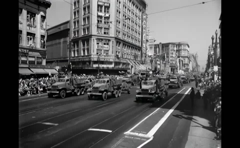SAN FRANCISCO - 1945 - Trucks pulling trailers down the street as spectators Stock Footage 308102800