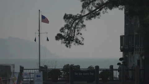 San Francisco, CA - Dec 12, 2024: Seaside with US flag, ocean and mountain Vídeos de archivo 333578290