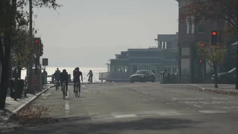 San Francisco, CA - Dec 12, 2024: Street on hillside with cyclists and ocean Stock Footage 333578312