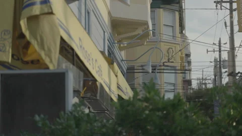 San Francisco, CA - Dec 15, 2024: Pale yellow cafe yellow building and shrub Stockbeeldmateriaal 333580639