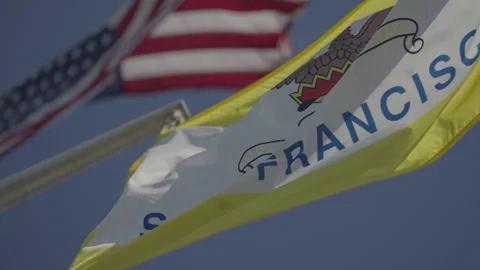 San Francisco, CA - Dec 15, 2024: Sharp SF flag with blurred US flag background Stock Footage 333580654