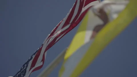 San Francisco, CA - Dec 15, 2024: Low angle US and SF flags with focus pull Stock Footage 333580677