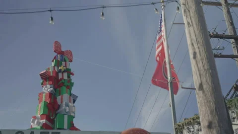 San Francisco, CA - Dec 15, 2024: Pile of gifts on cafe roof with US flag right Stock Footage 333616756