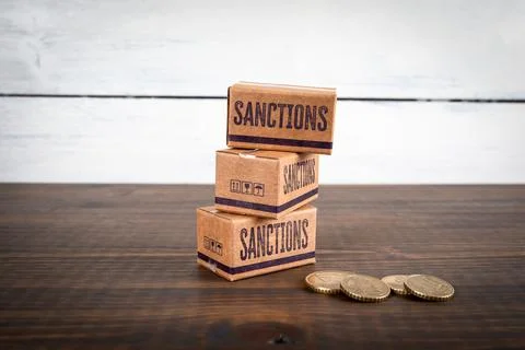 Sanctions Boxes and Coins Representing Economic Restrictions and Financial .. Stock Photos