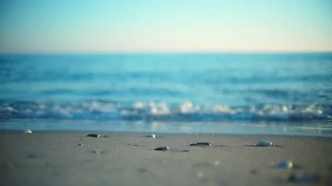 Sand and pebbles at the beach with defocused ocean waves behind it Vidéo 146821573