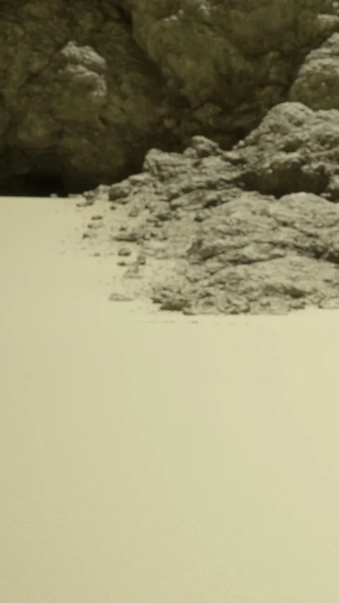 Sand and rocks at the beach during low tide with gentle waves in the background Stock Footage 334173158