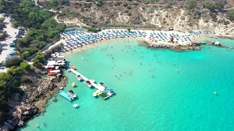 Sand and stone Beach with crystal blue water from drone. Jumping and swiming Stock Footage 153470053