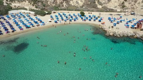 Sand and stone Beach with crystal blue water from drone. Jumping and swiming Stock Footage 153473134