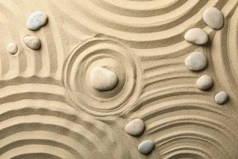 Sand and stones pattern with ripples and circles on beach Stock Photos
