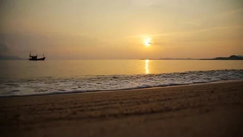 Sand and waves with boat on the beach with sunset Stock Footage 75464545