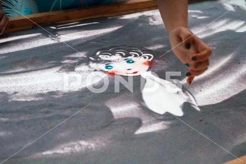 Sand animation, drawing sand closeup, girl drawing an angel on the sand Stock Photos