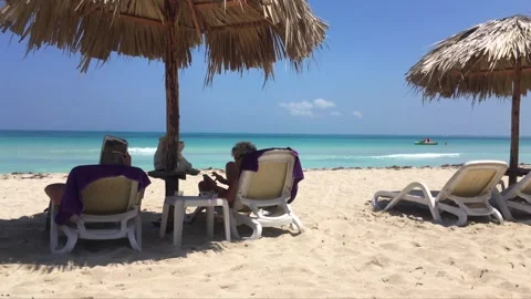 Sand beach and straw umbrellas in Varadero, Cuba with white sunbeds and blue Stock Footage 301074807