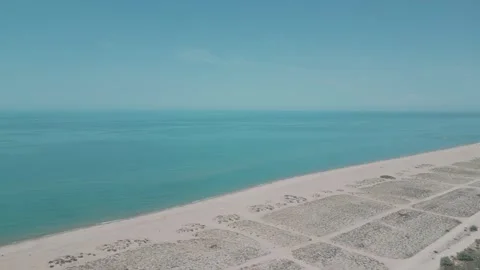 Sand beach with drying seaweed washed by turquoise water Stock-Footage 247761692