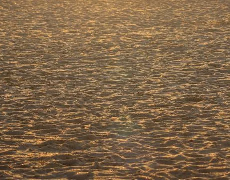 The sand on the beach gilded by the sunset Stock Photos