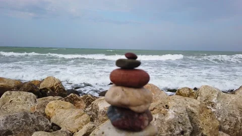 Sand beach. Large sea waves with white foam. tower of stones, stone pyramid. Vidéo 143893892