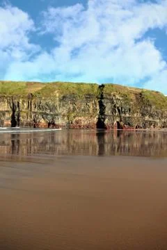 Sand beach side cliffs and sky Stock Photos