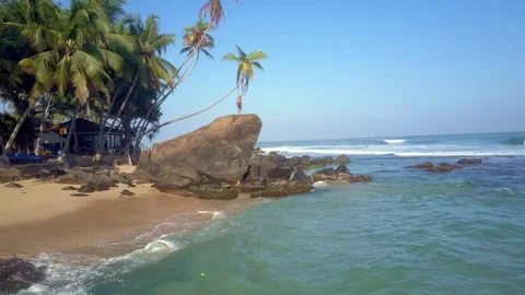 Sand beach washed by azure ocean with resting tourists Stock Footage 248050845