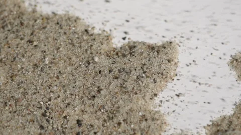 Sand that is being blown across a white backdrop Stock Footage 88049320
