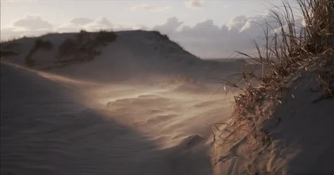 Sand being blown through a shaft of light in dunes Stock Footage 83859245