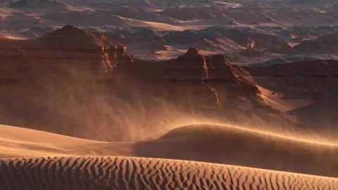 Sand blowing over dunes in wind, red cliffs on background, Gobi desert. Mongolia Vídeo Stock 231477124