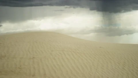 Sand blows across dune as imposing thunderstorm approaches on summer afternoon Stock-Footage 247985953