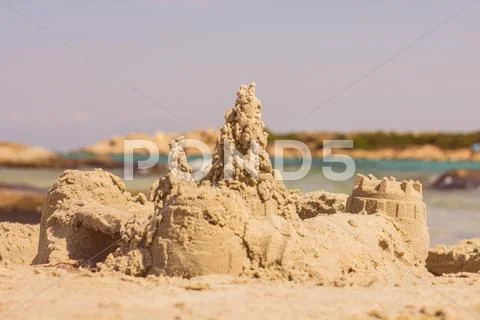 Sand castle on the beach, summer vacation. Stock Photos