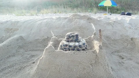 Sand castle with shaells on it reveal. Sun flare. Stock Footage 80758091
