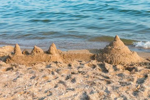 Sand castle with shells built on a summer sea beach against the backdrop of the Stock Photos