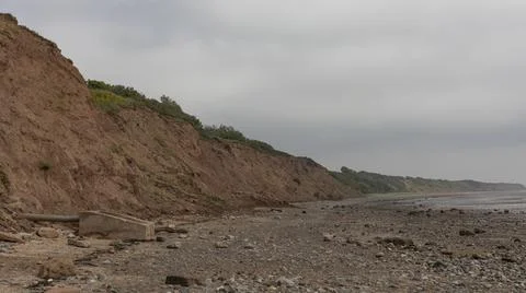 Sand cliffs to the left on a beach Stock Photos