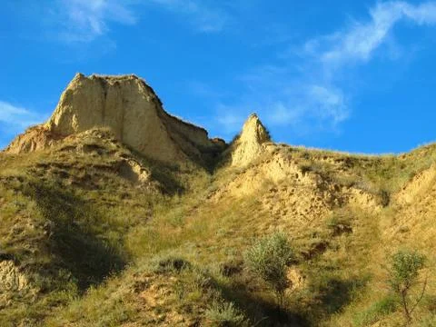 Sand cliffs at sunset on a blue sky background. Stock Photos