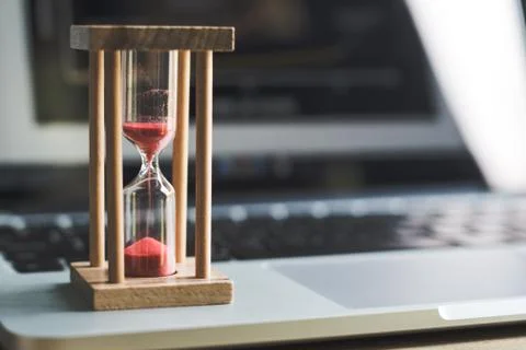 Sand clock timer on laptop .symbol of time Stock Photos