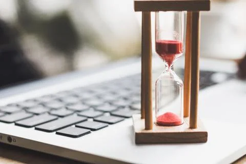 Sand clock timer on laptop .symbol of time Stock Photos