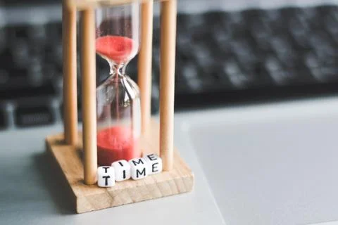 Sand clock timer on laptop with "TIME" alphabet cube letter .symbol of time Stock Photos