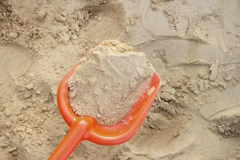 Sand collected in an orange spade Stock Photos